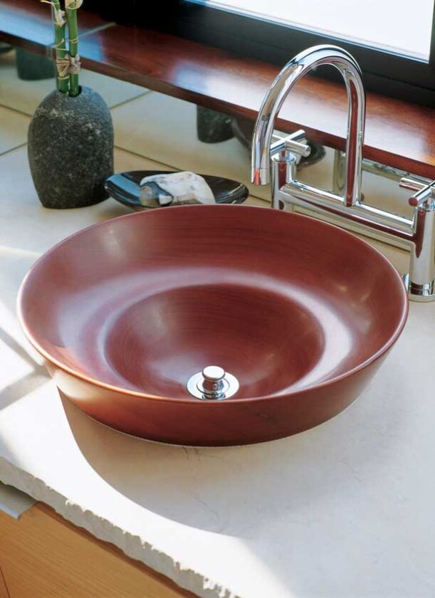 Light dances on wood, stone, and plaster surfaces in the home. The wooden sink basin adds rich texture to the master bathroom.